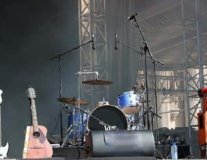 Drum set on stage with overhead mics.