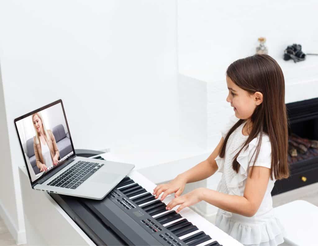 Young girl taking online piano lessons.
