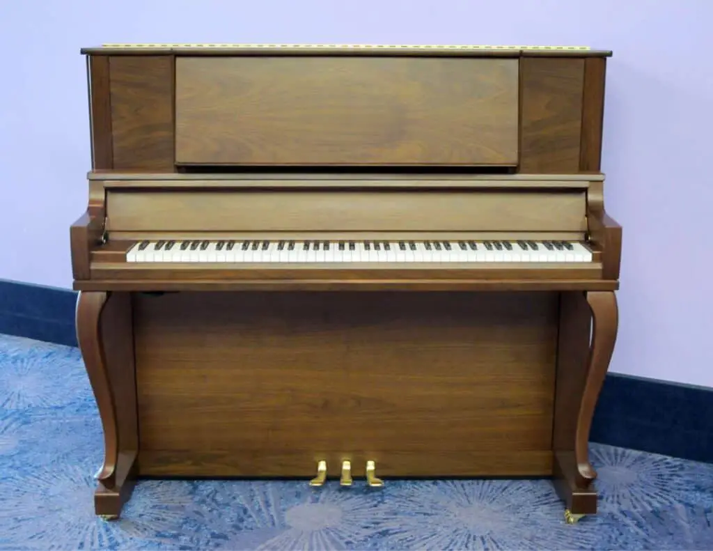 Upright piano in purple room.