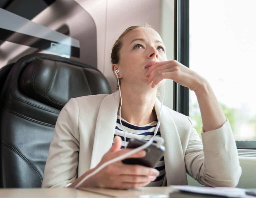 Woman listening to music while traveling on a train.
