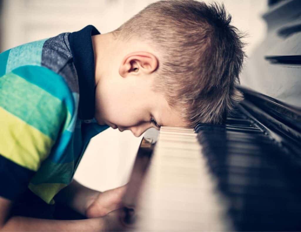 Frustrated boy playing piano.